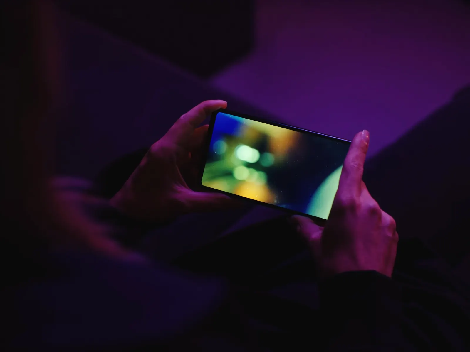 Oglądanie telewizji na telefonie wieczorem na kanapie